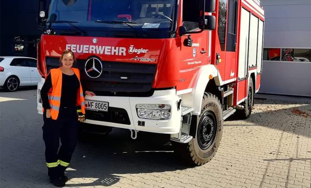 Produktmanagerin Desiree Fuhs vor einem Feuerwehrauto
